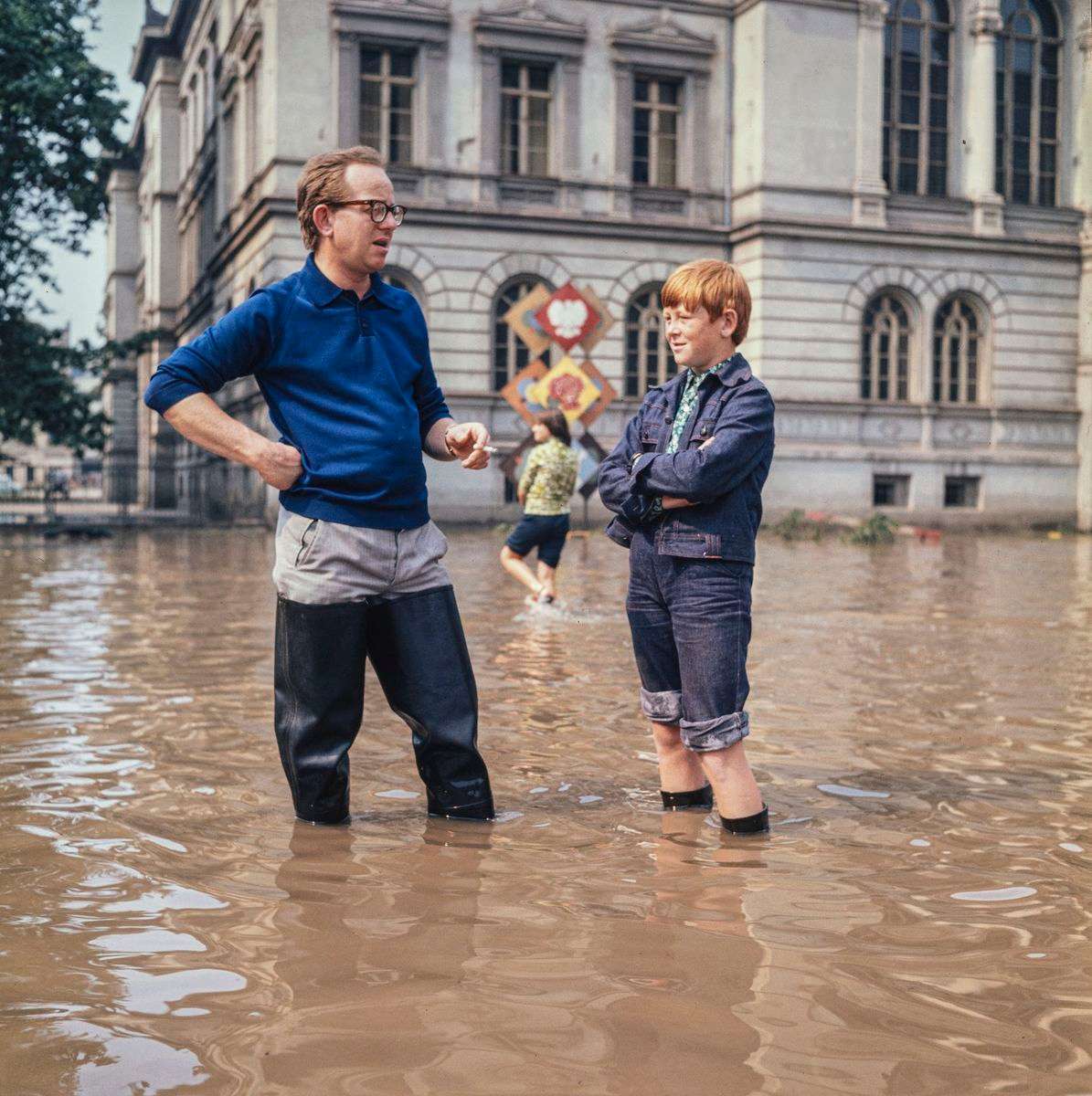 Dwóch mężczyzn stojących na zalanym terenie.