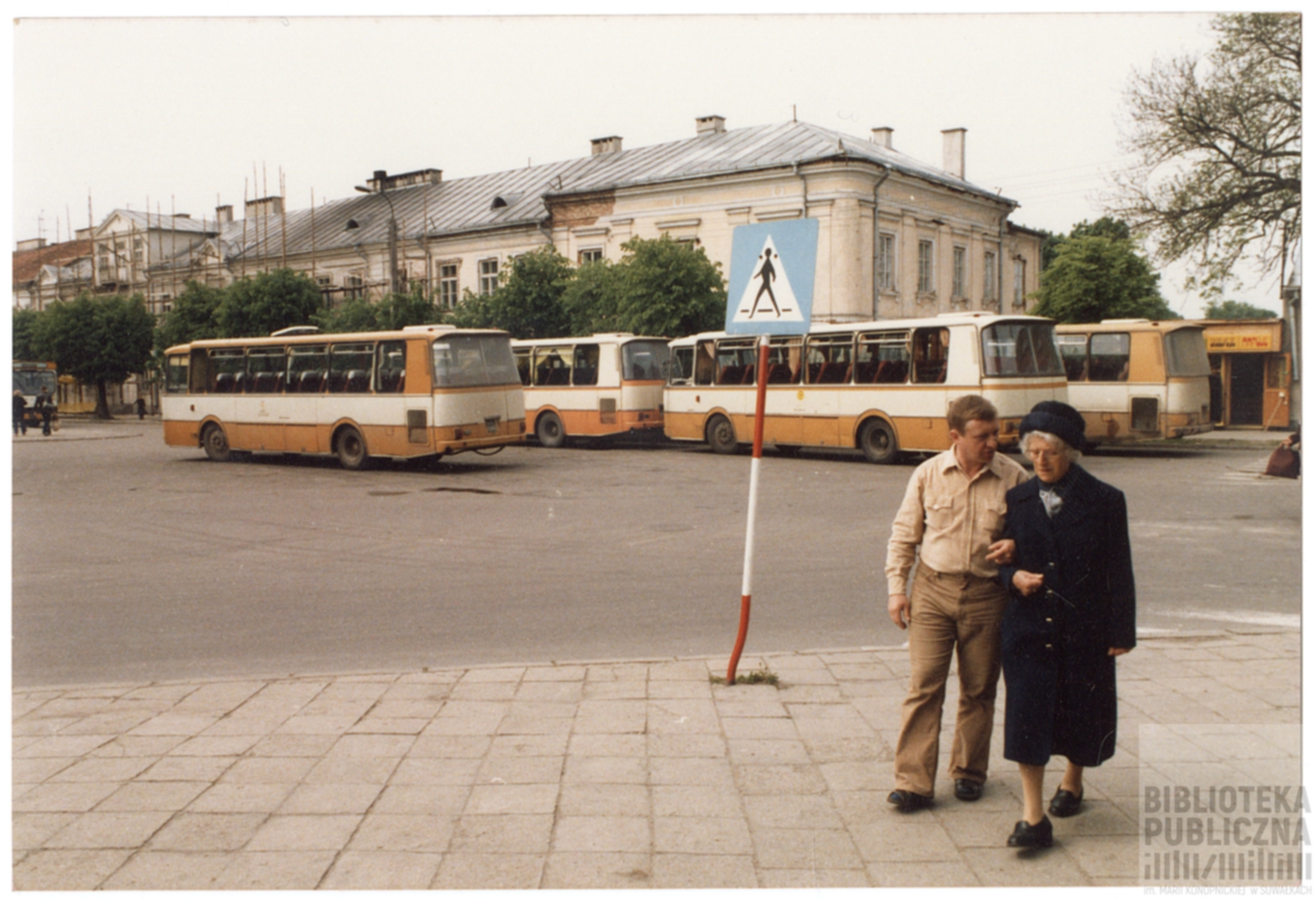 Mężczyzna i kobieta stojący przed autobusem.