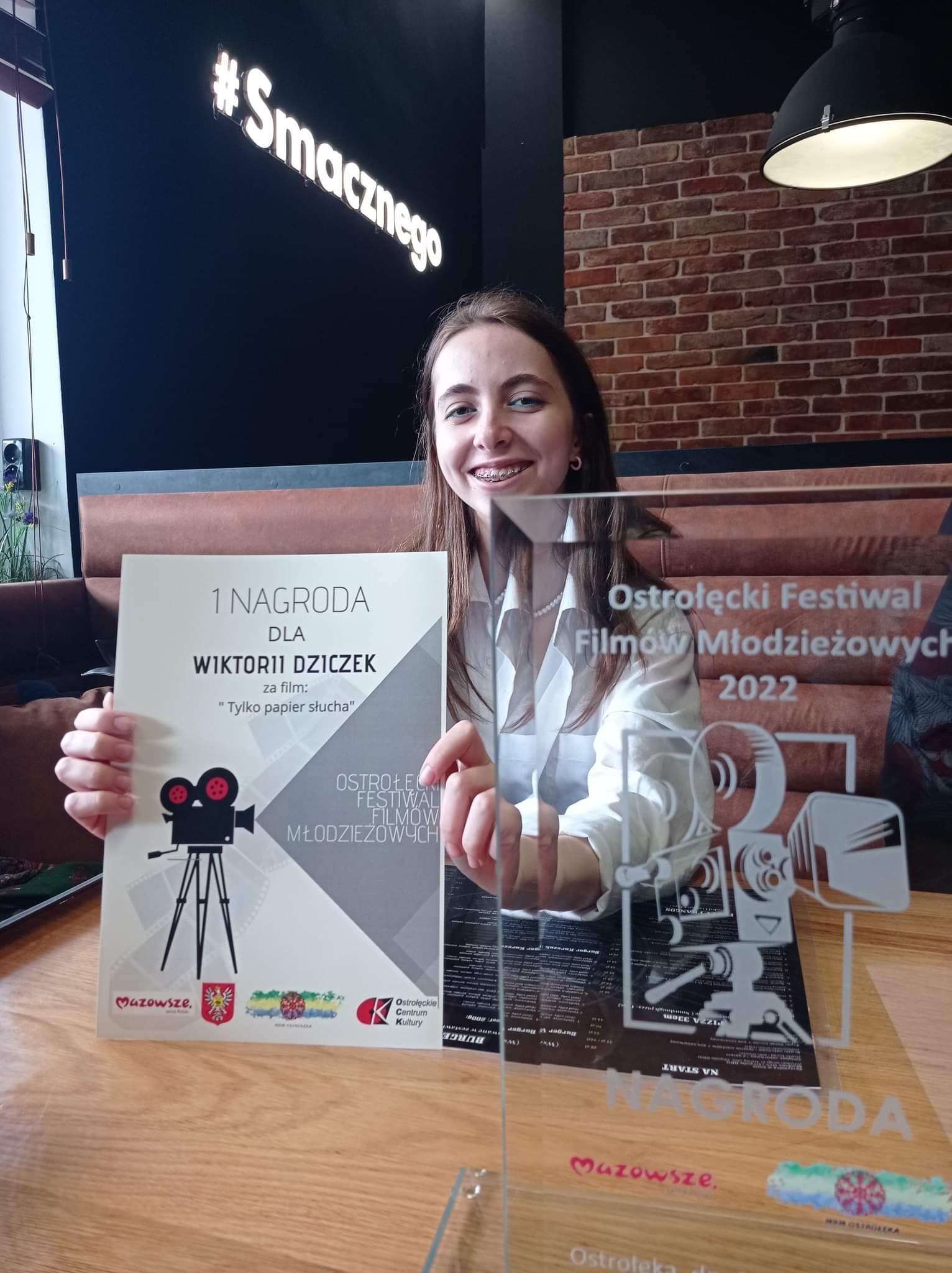 Kobieta trzyma nagrodę na festiwalu filmowym.