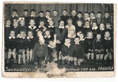 Czarno-białe zdjęcie klasowe ze Szkoły w Szczuczynie, rok szkolny 1960-61, przedstawiające grupę dzieci i nauczyciela, siedzących i stojących w rzędach.