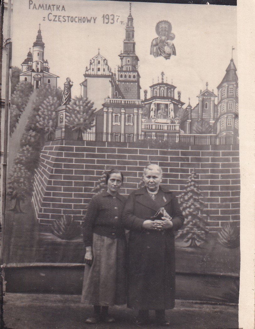 Mężczyzna i kobieta stoją na tle częstochowskich budynków, nad którymi widoczny jest napis „Pamiątka z Częstochowy 1937r”.