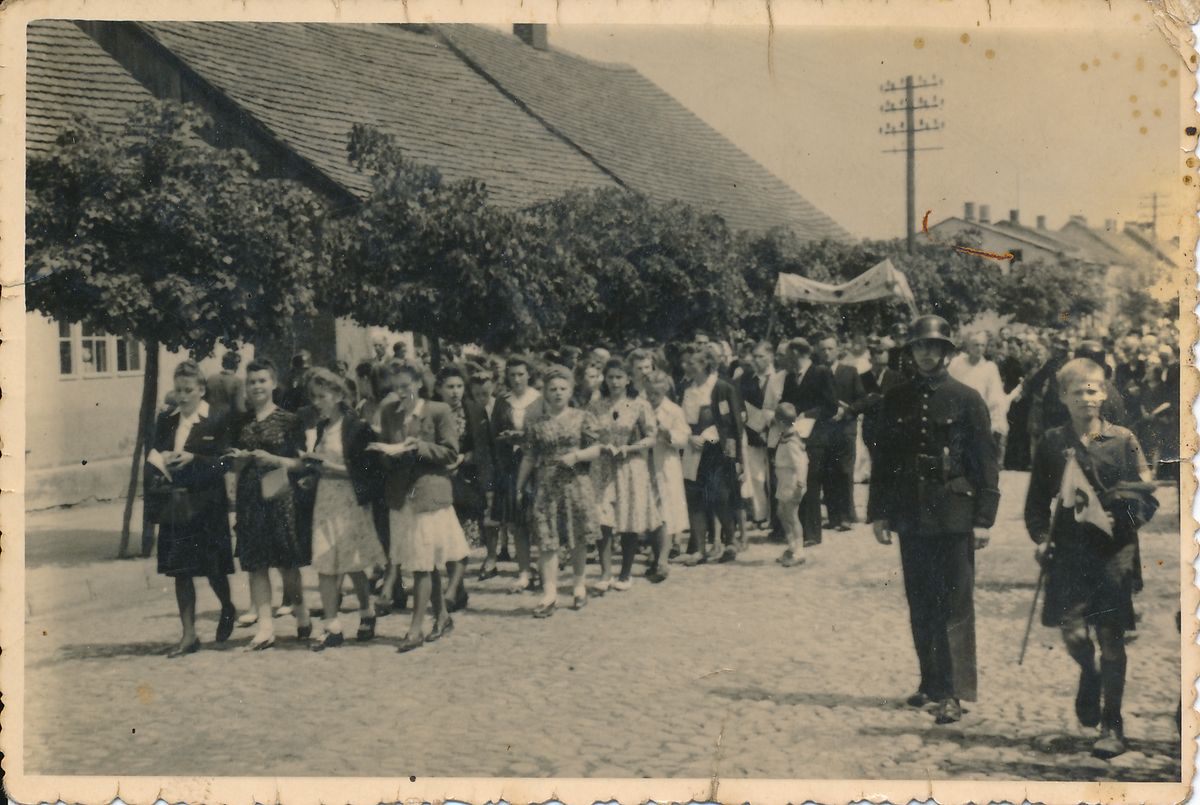 Grupa osób stojących w kolejce.