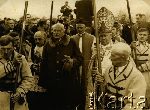 Grupa mężczyzn w szatach stojących przed kościołem.