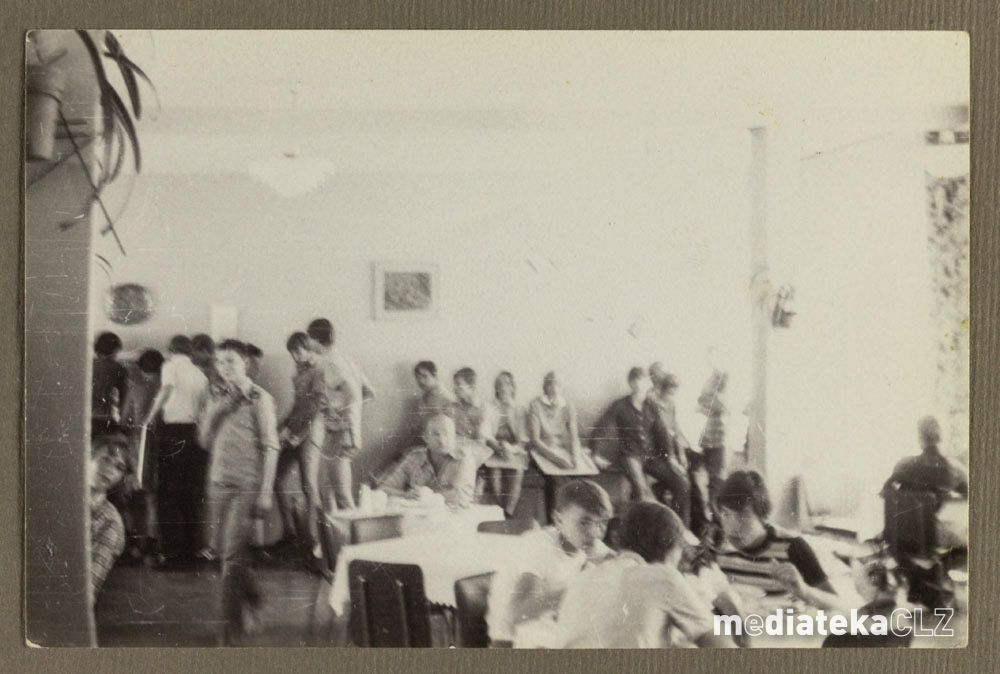 Stare zdjęcie przedstawiające grupę osób w pokoju.