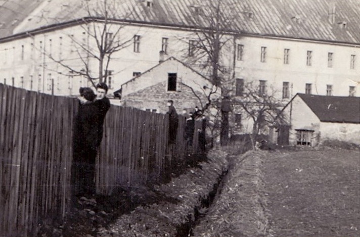 Stare zdjęcie ogrodzenia przed budynkiem.