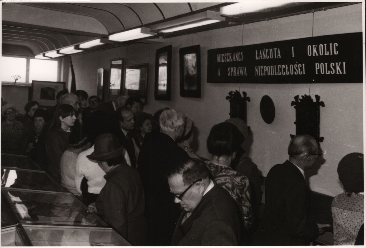 Grupa ludzi stojących w kolejce w muzeum.