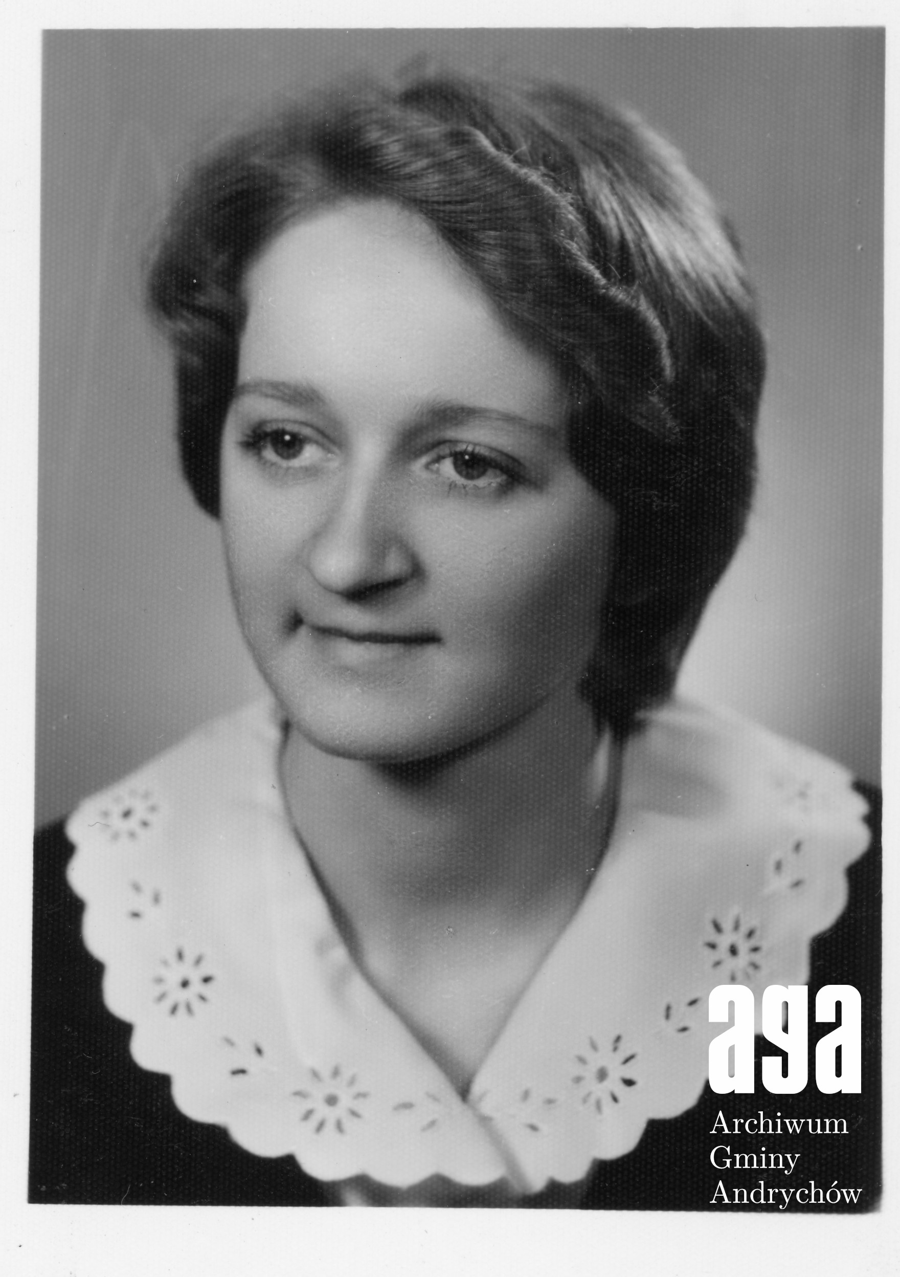 Czarno-biały portret kobiety z krótkimi włosami, ubranej w bluzkę z ozdobnym kołnierzykiem.